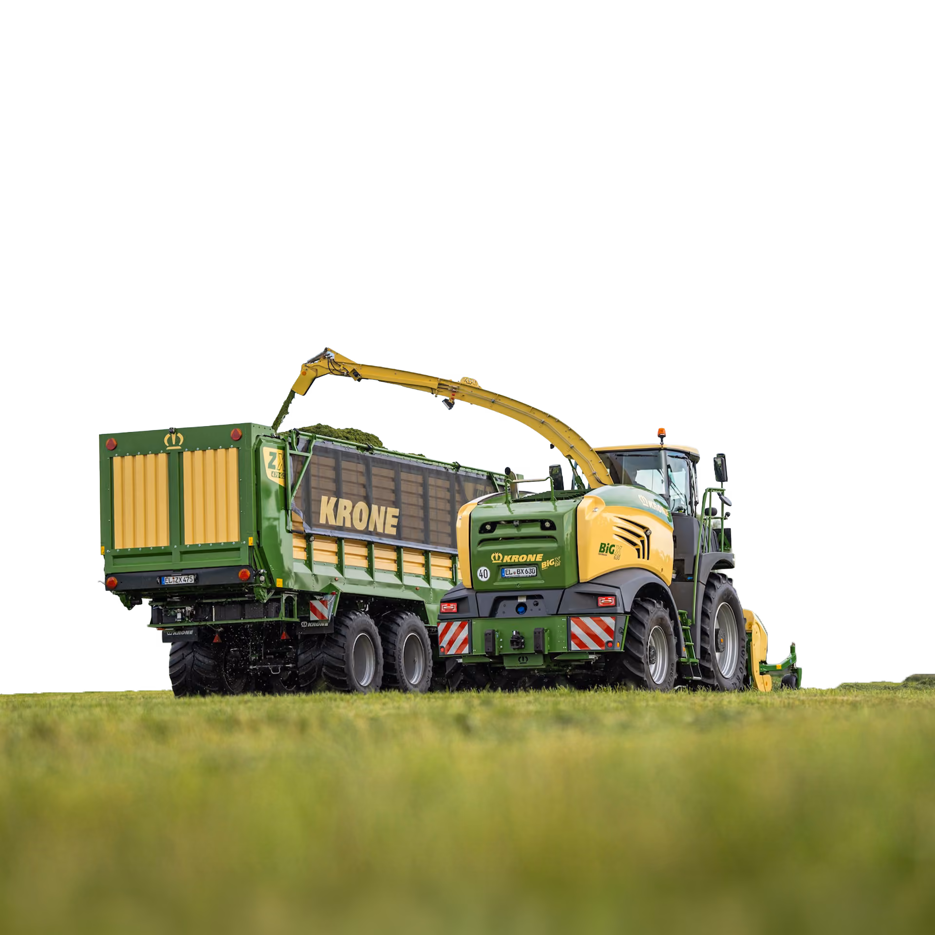 Green and yellow Krone agricultural forage harvester machine loading grass or crops into a green Krone trailer with wooden panels on a field.