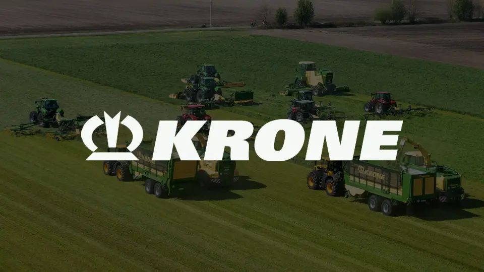 Several green and red agricultural tractors and machines working on a large grassy field, with the white KRONE logo overlaid at the center.
