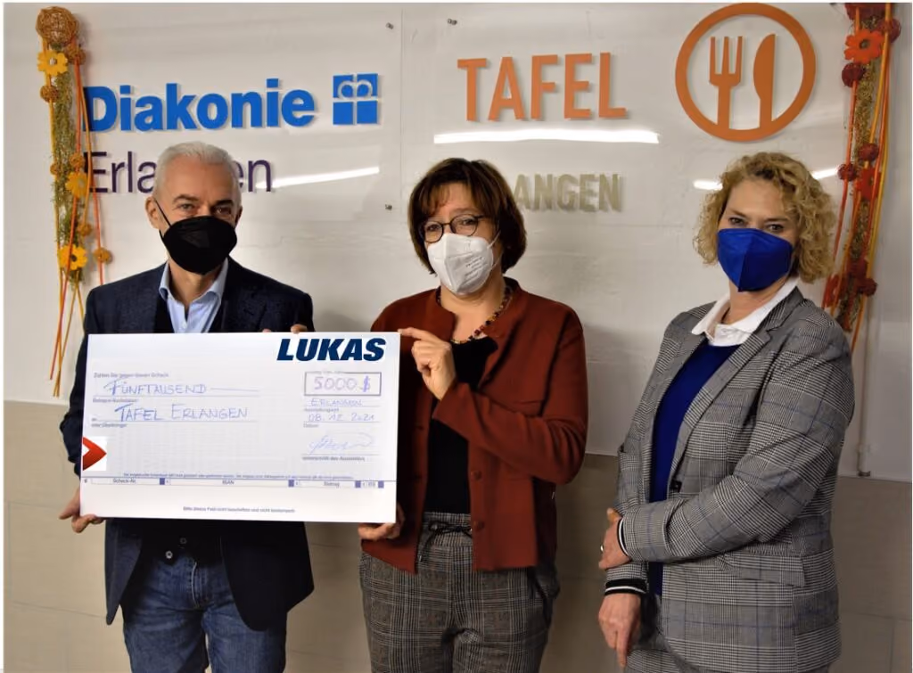 Three people holding a $5000 donation check