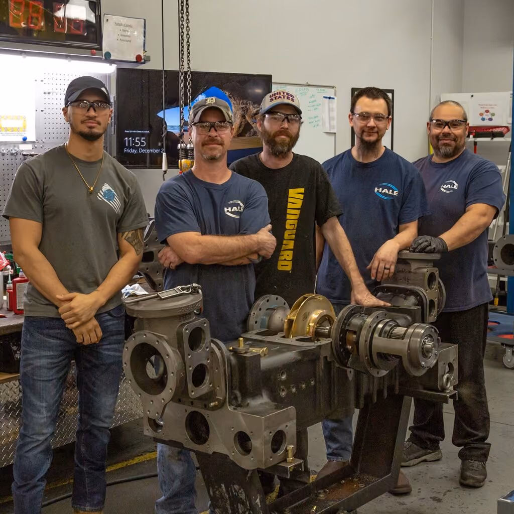 Hale team members standing with a large piece of machinery