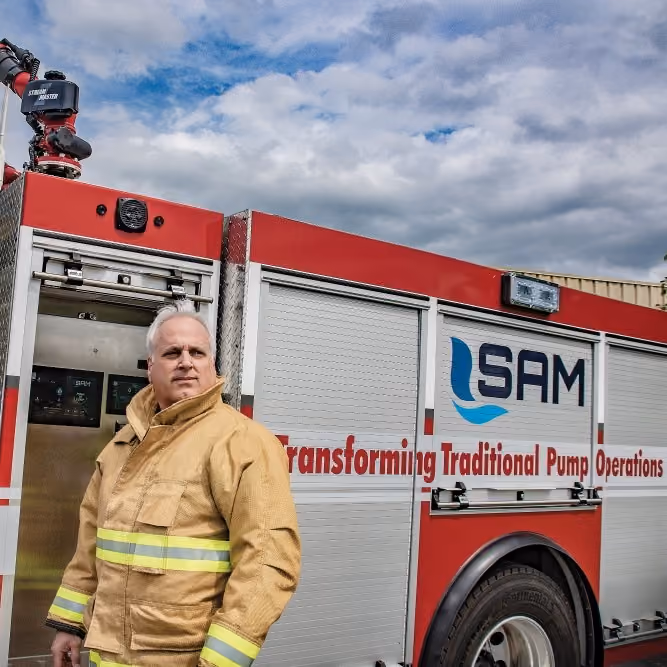 A fire fighter in front of a SAM fire truck