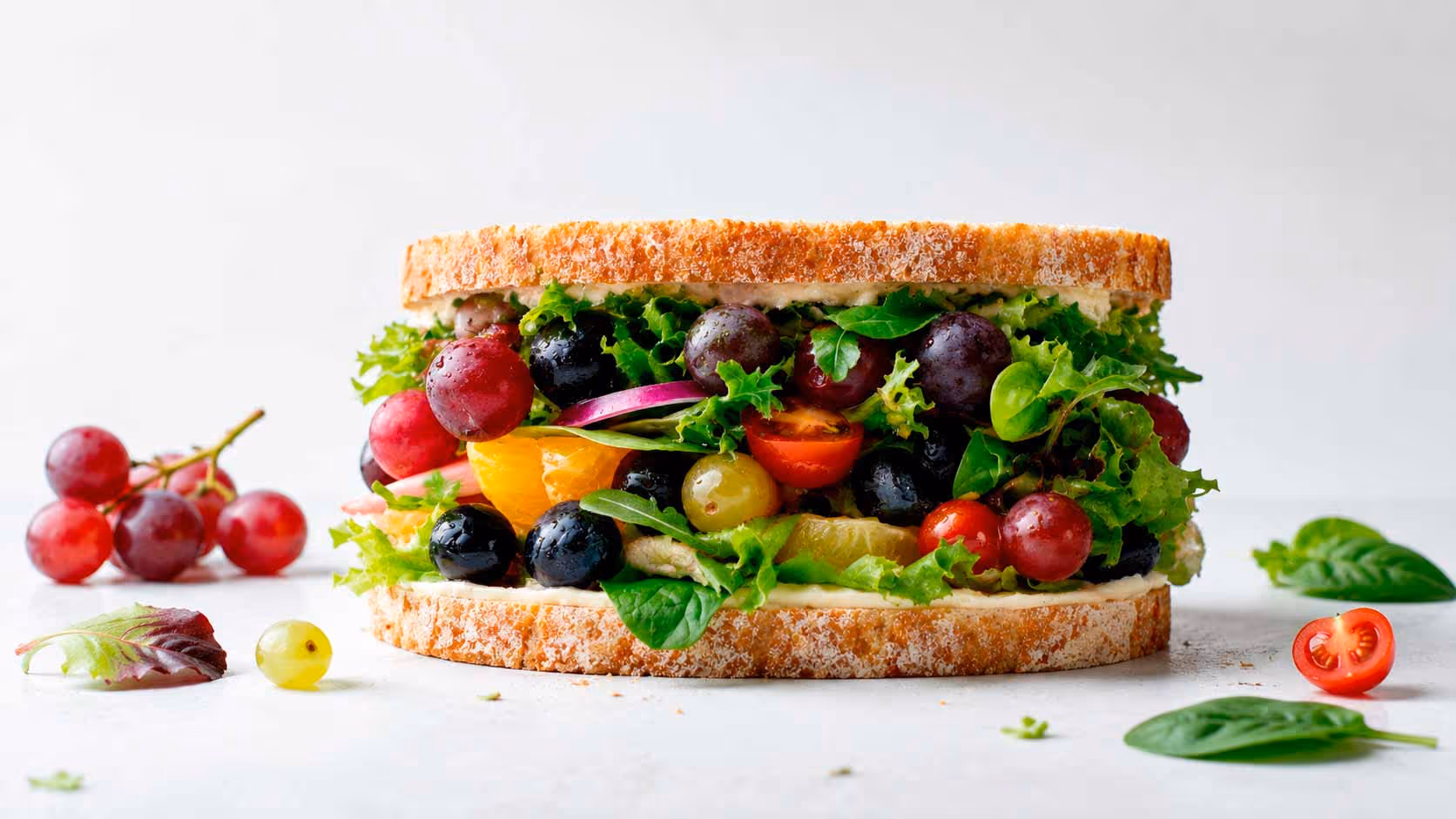 A sandwich with a variety of vegetables and fruits.