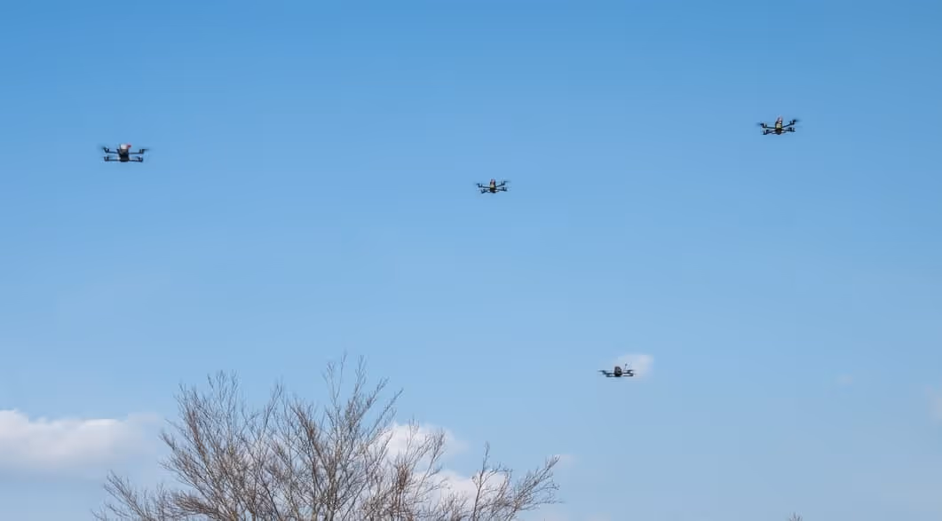 A group of airplanes flying through a blue sky.