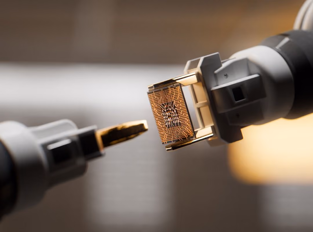 Close-up of two robotic arms holding a microchip with intricate circuitry patterns.