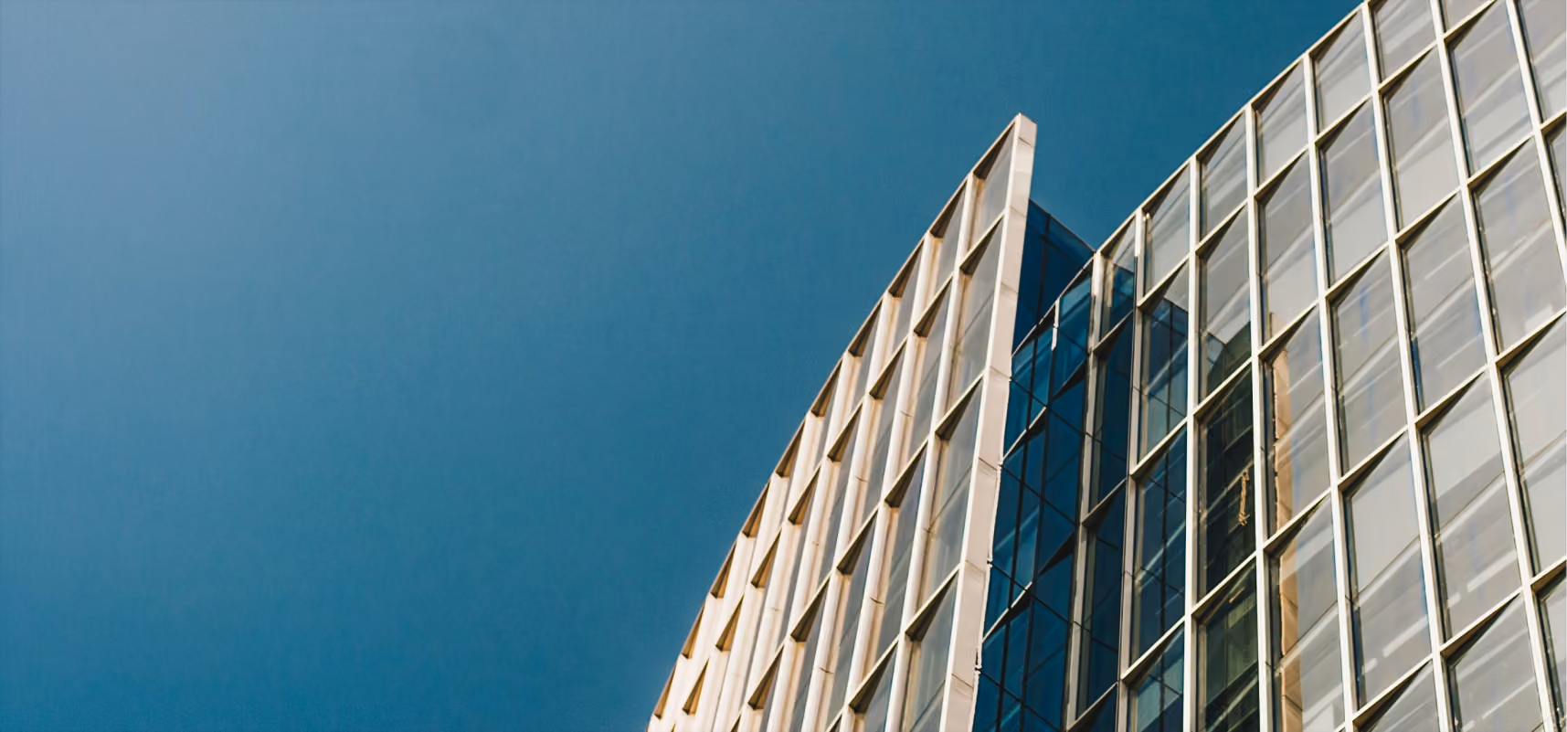 High rise building with blue sky to the left of it.