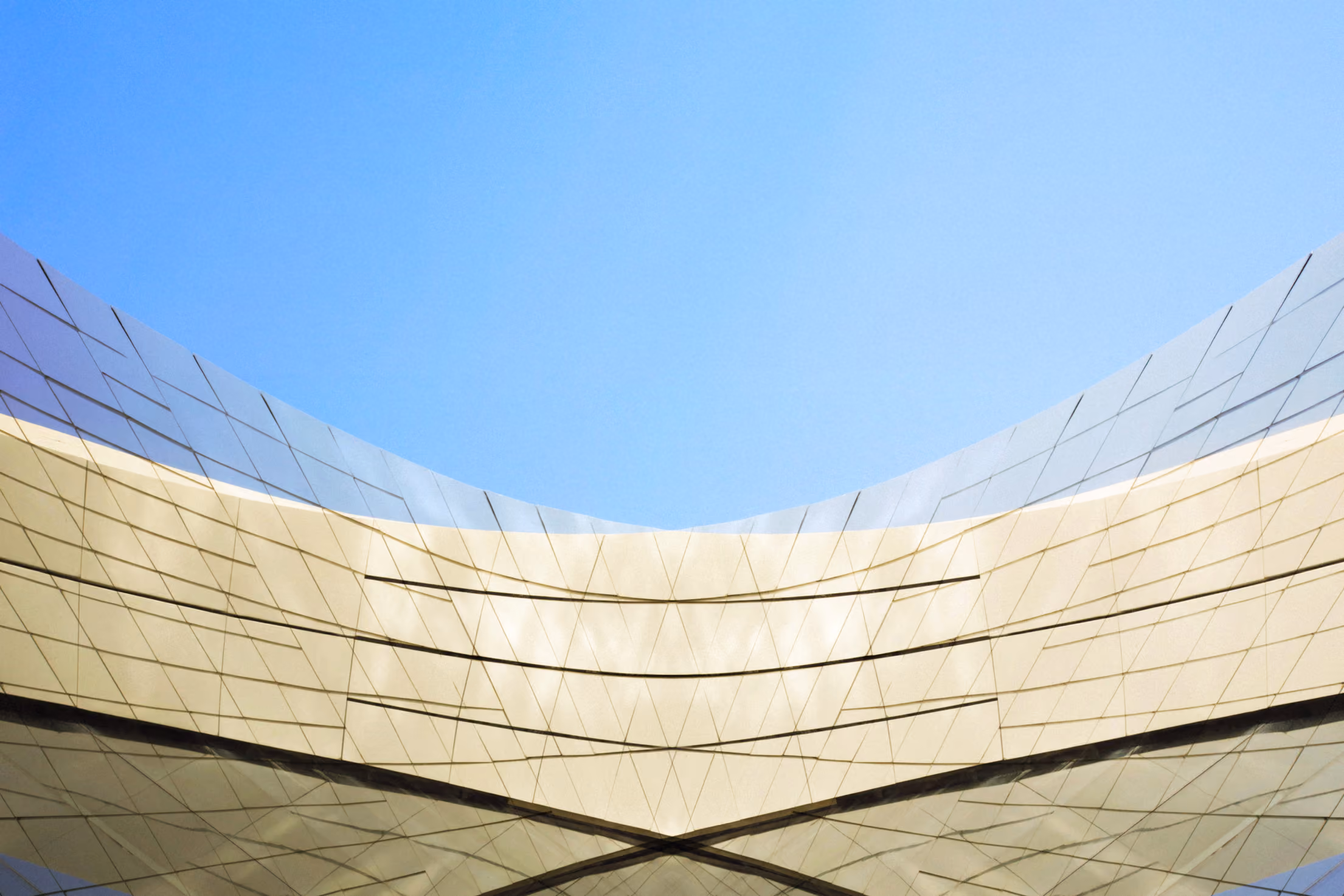 Interesting architectural image with reflections on a modern, curved building.