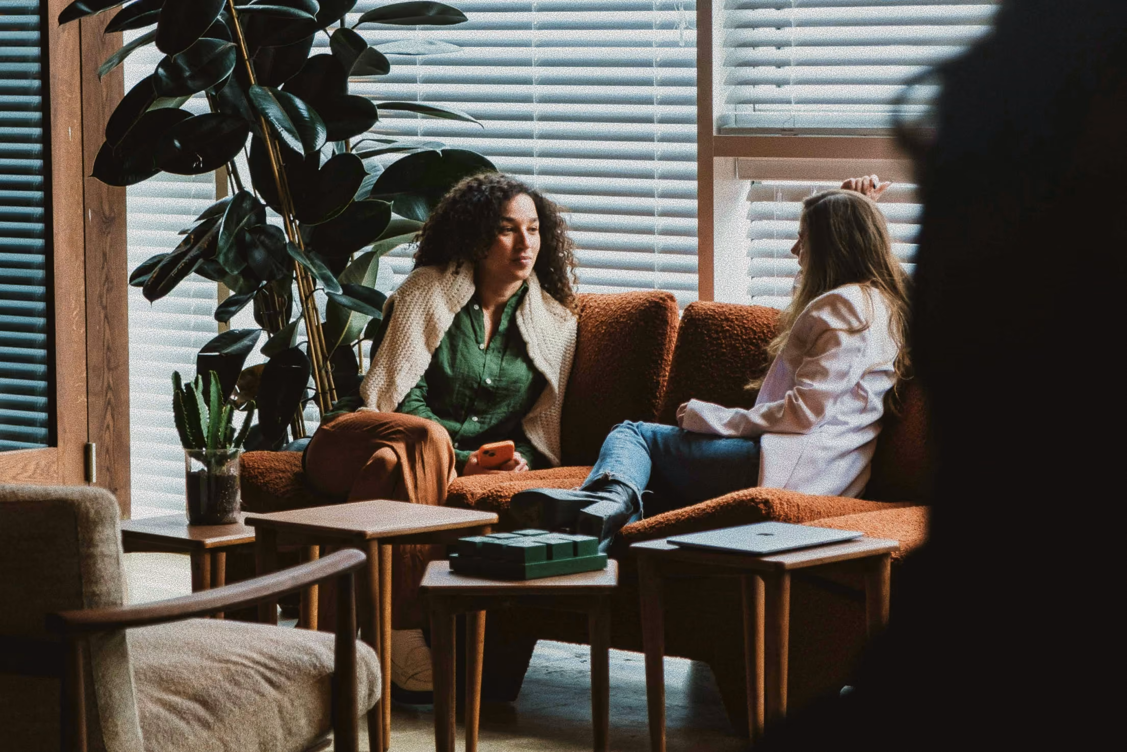 Two people sitting on a sofa talking
