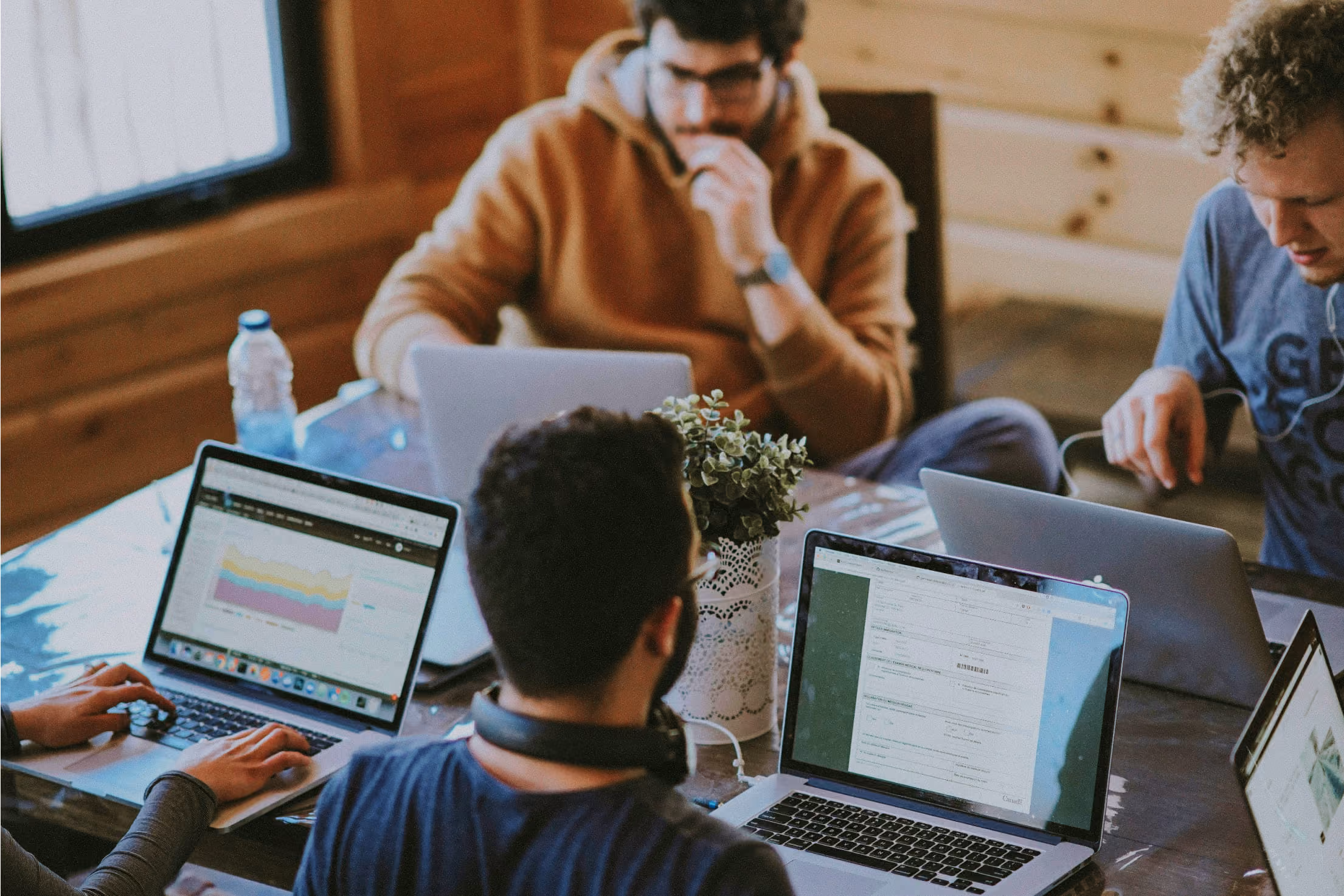 Two people gathered around a table working at their laptops.