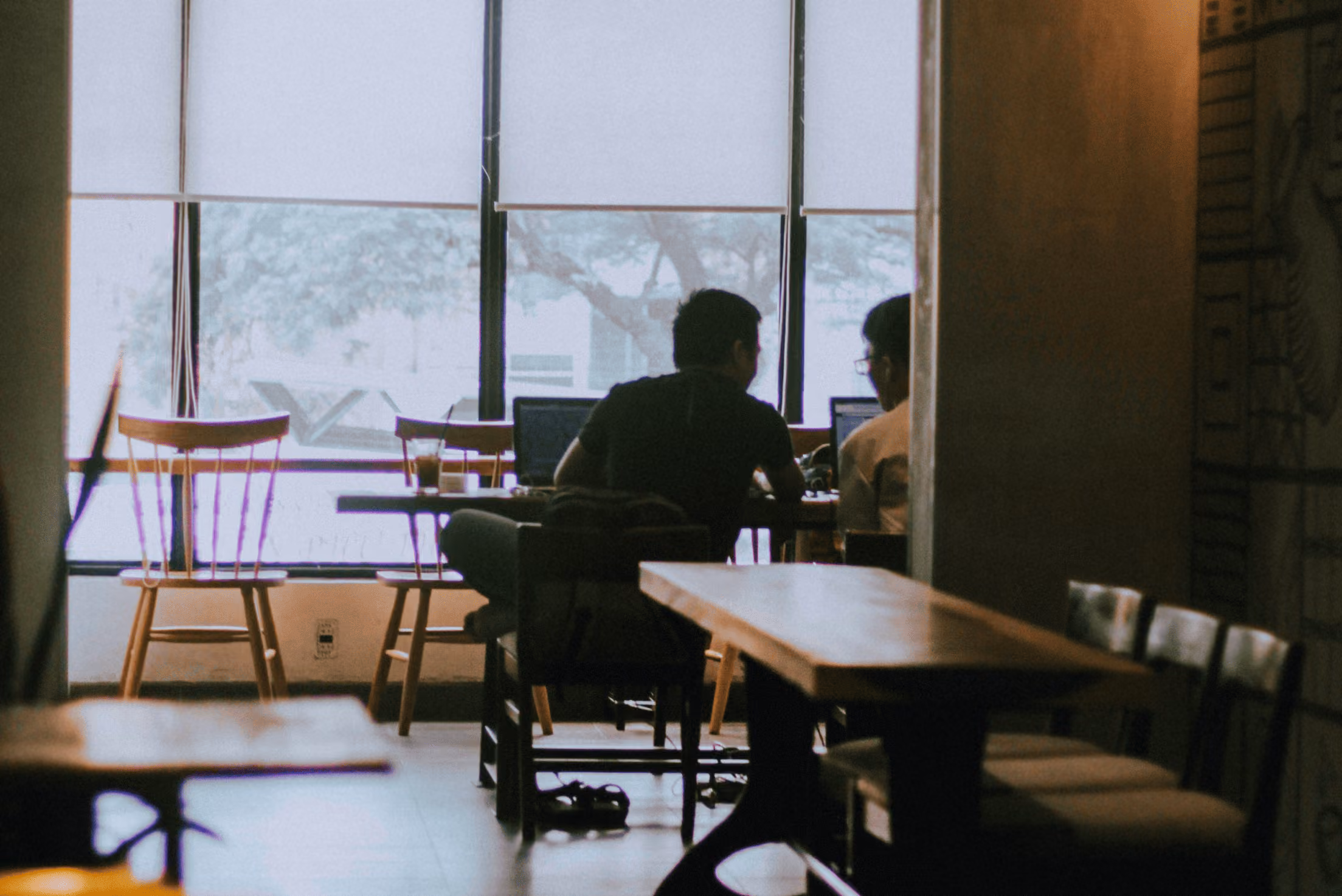 Two people sitting at a table in a cafe.
