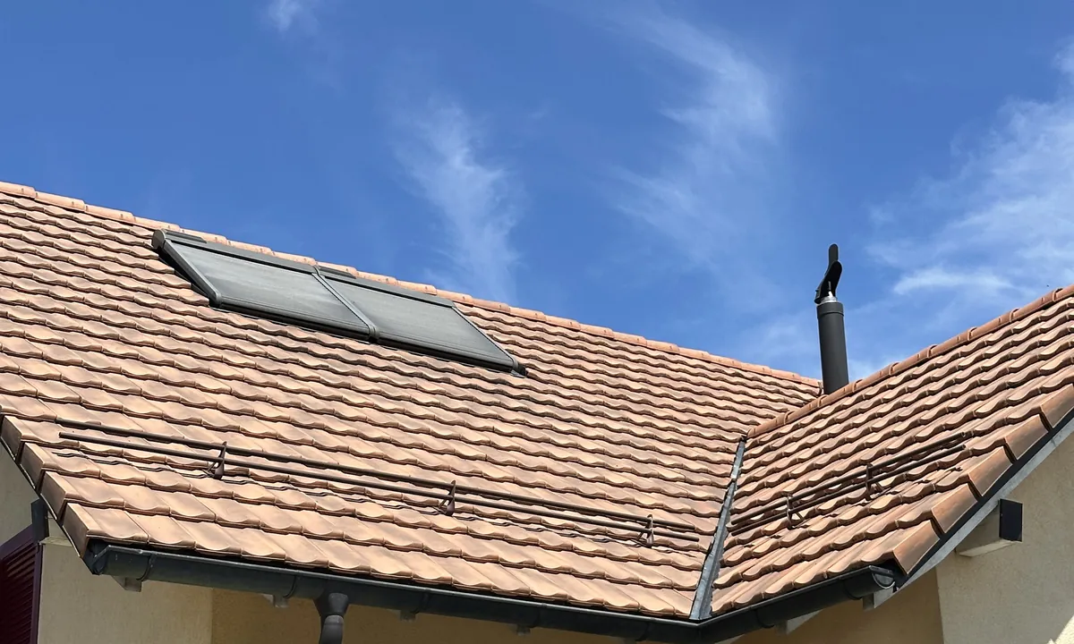 Toiture en tuiles avec fenêtre de toit, après le nettoyage