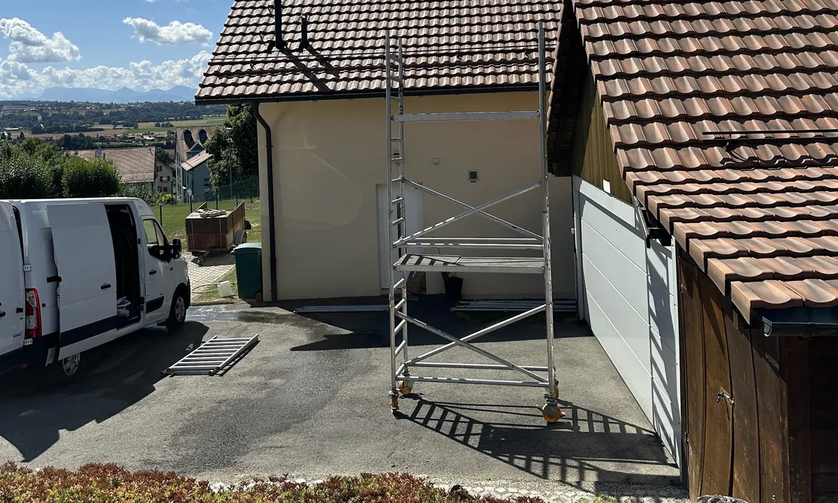 Échafaudage roulant installé contre une maison pour un nettoyage de toiture