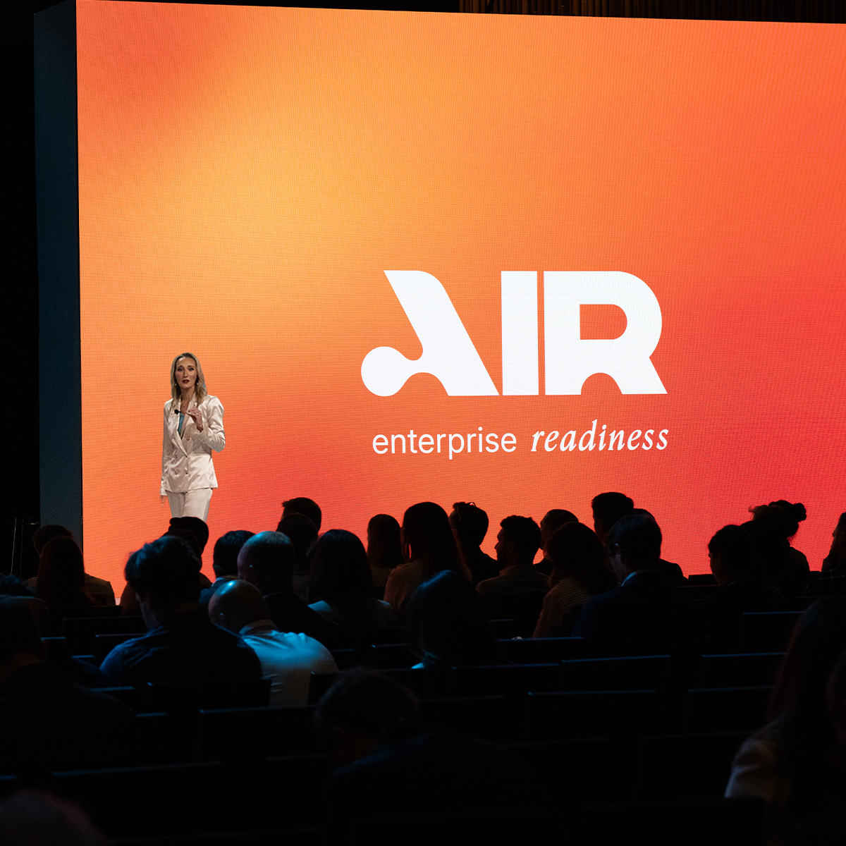 Tara Murphy Dougherty on stage at Reindustrialize 2026, announcing Govini's rebrand to Air Enterprise Readiness
