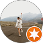 Man walking on rough terrain outdoors holding a phone with an orange star icon overlay.