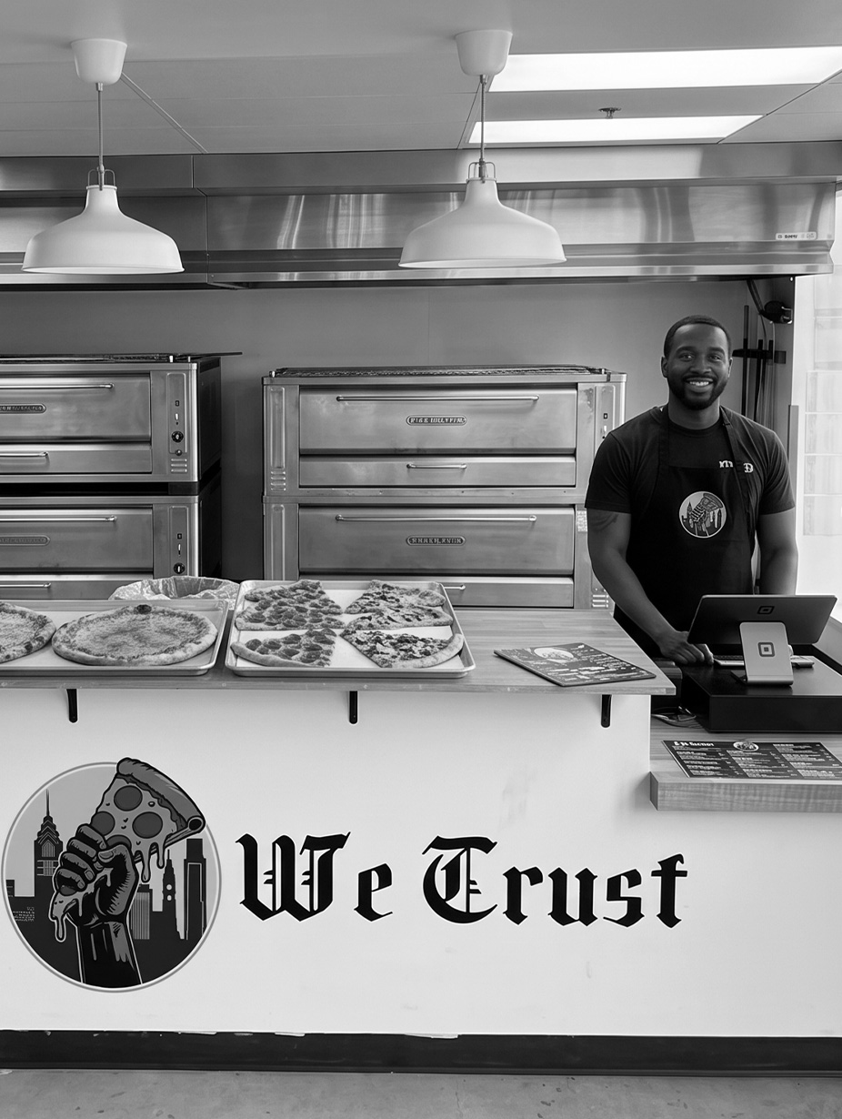 Chef placing cheese on raw pizza bread