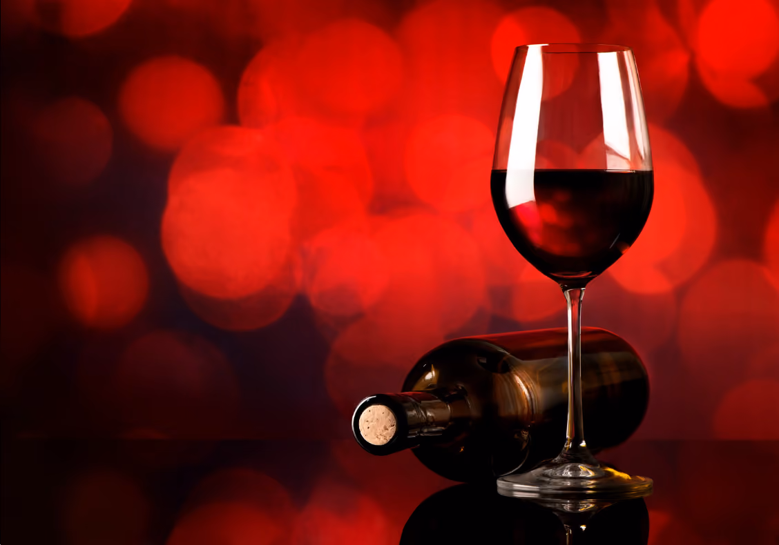 Red win glass and bottle on red background