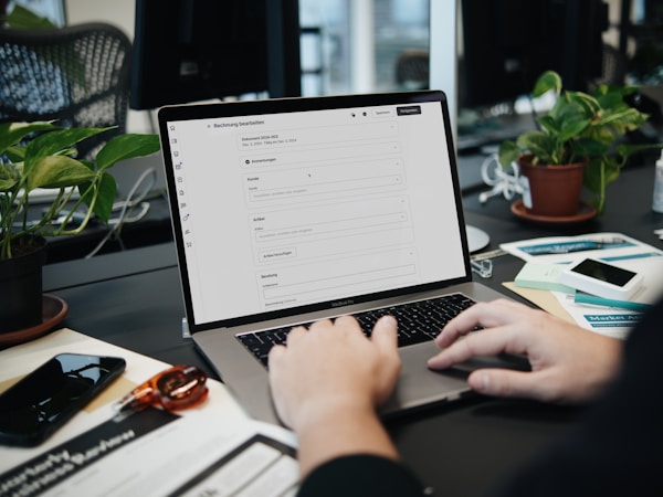 A cozy office setting with a professional reviewing an invoice online. SumUp helps you streamline your invoicing process.