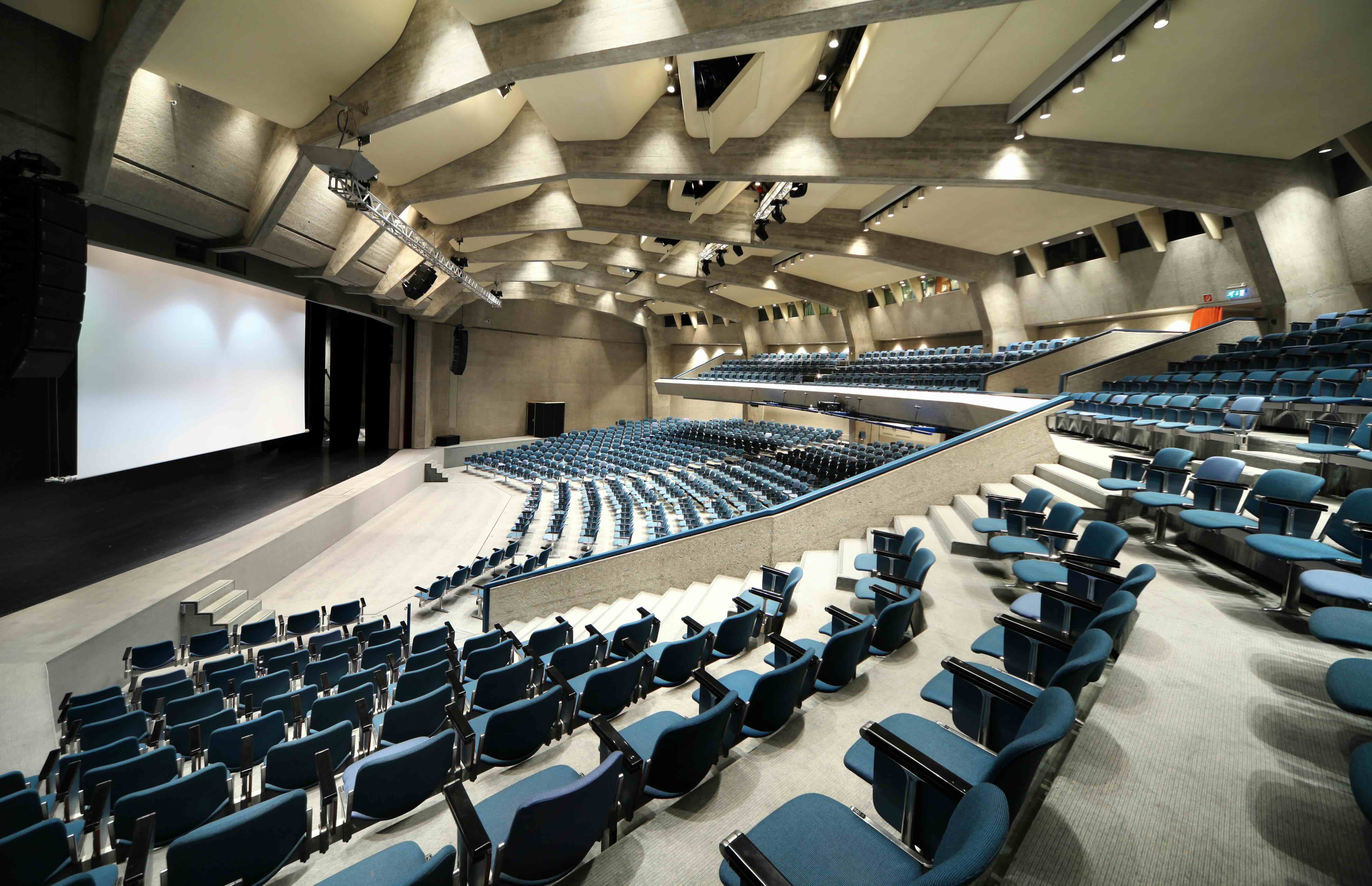 Auditorium interior with tiered seating and acoustic wall treatment