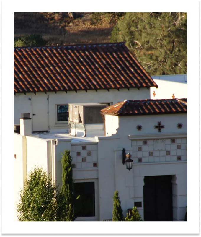 Red tile roofs and cross details on the white stucco mission-style Villa La Paz building