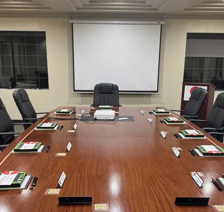 Executive boardroom with leather chairs, projection screen, and meeting materials at each seat