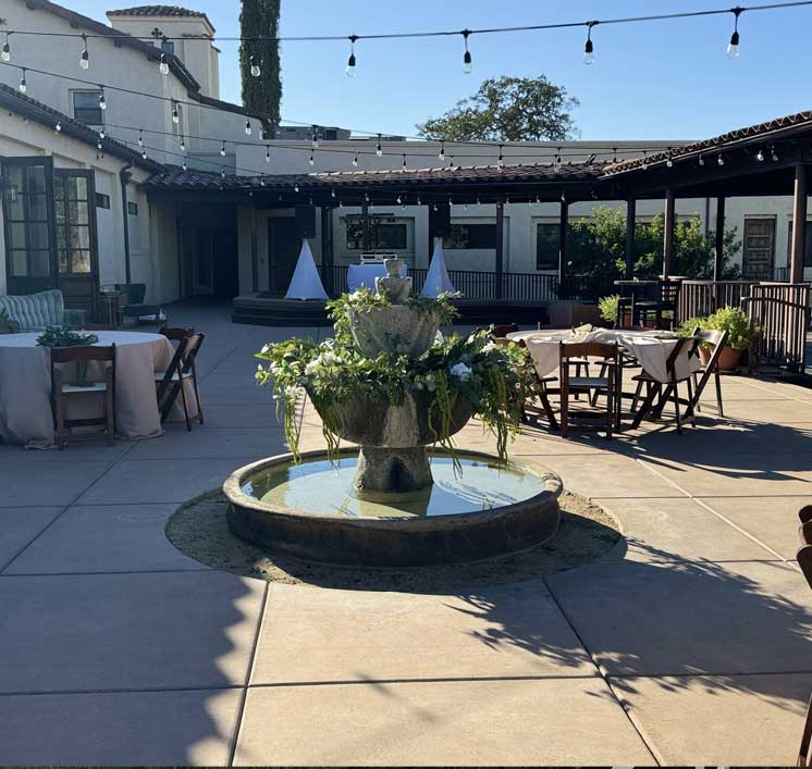 Flower-dressed tiered fountain and string lights in the Villa La Paz courtyard set for an event
