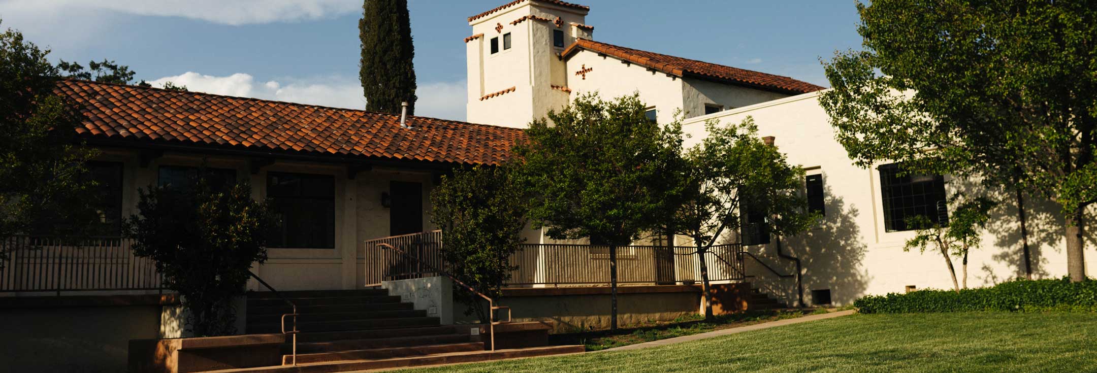Mission-style tower and tiled rooftops of Villa La Paz above a landscaped lawn