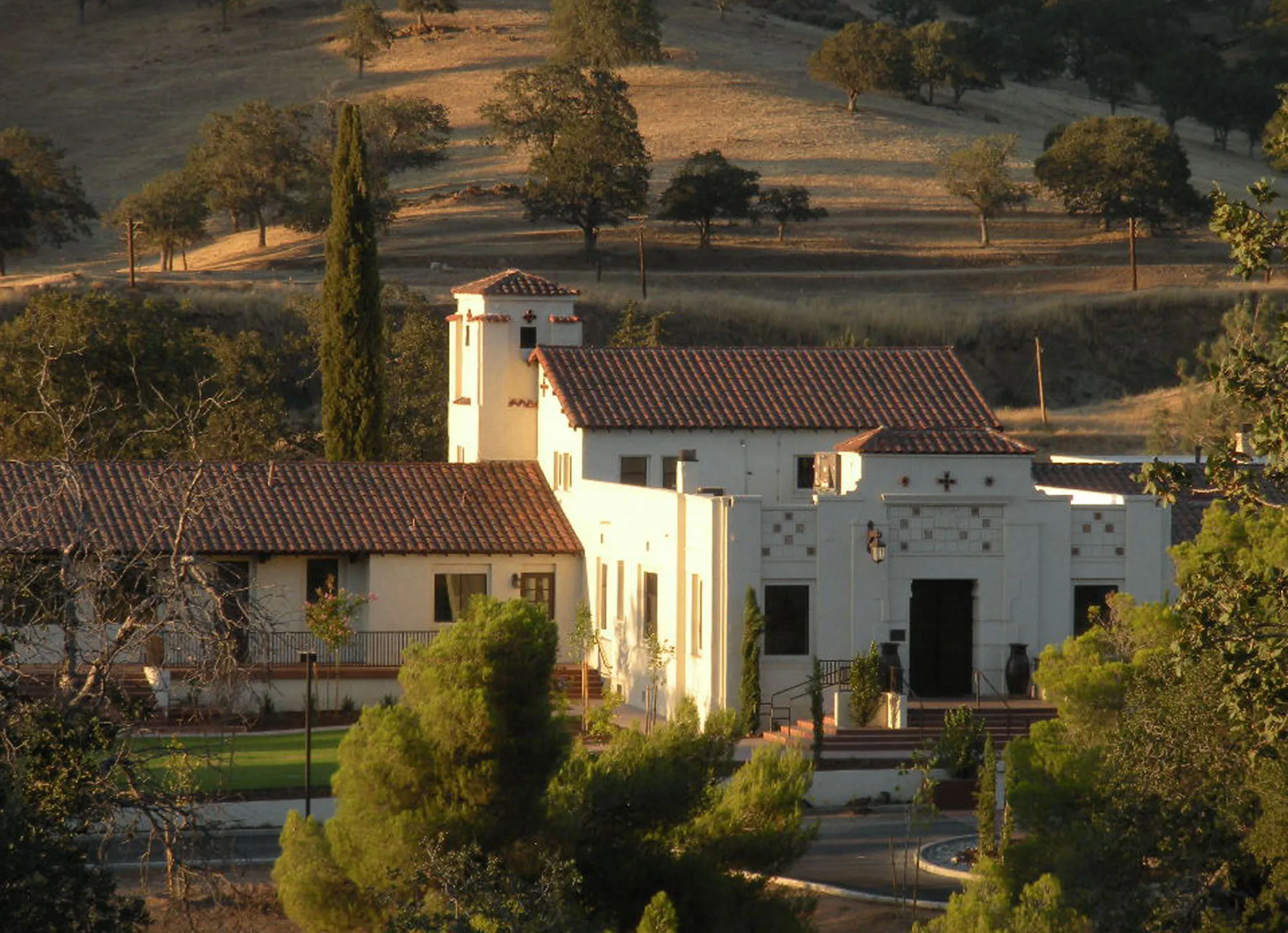 Villa La Paz's white mission-style buildings and red tile roofs glowing at sunset in the Tehachapi foothills