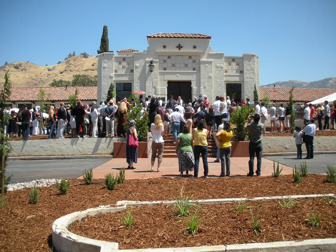 Crowd gathered outside the white mission-style Villa La Paz building beneath the Tehachapi hills
