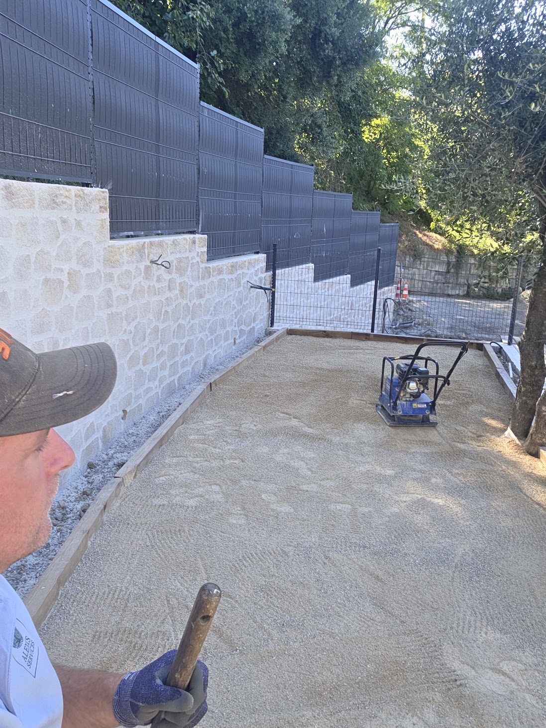 Compactage du stabilisé à la plaque vibrante sur un terrain de boules à Vence