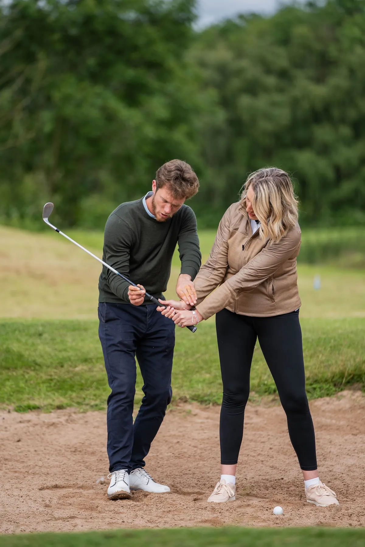 Coach guiding a student through grip technique during a private golf lesson in Derbyshire.
