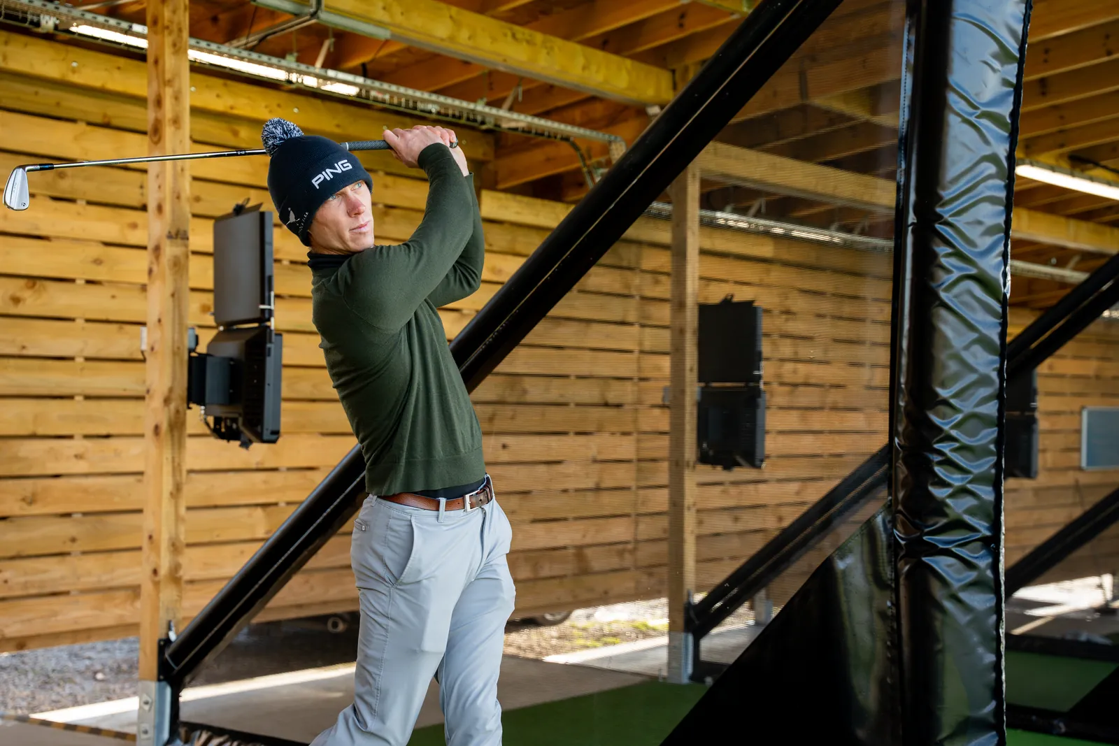 Student working on swing mechanics inside a driving range bay at Evolution Golf Academy.