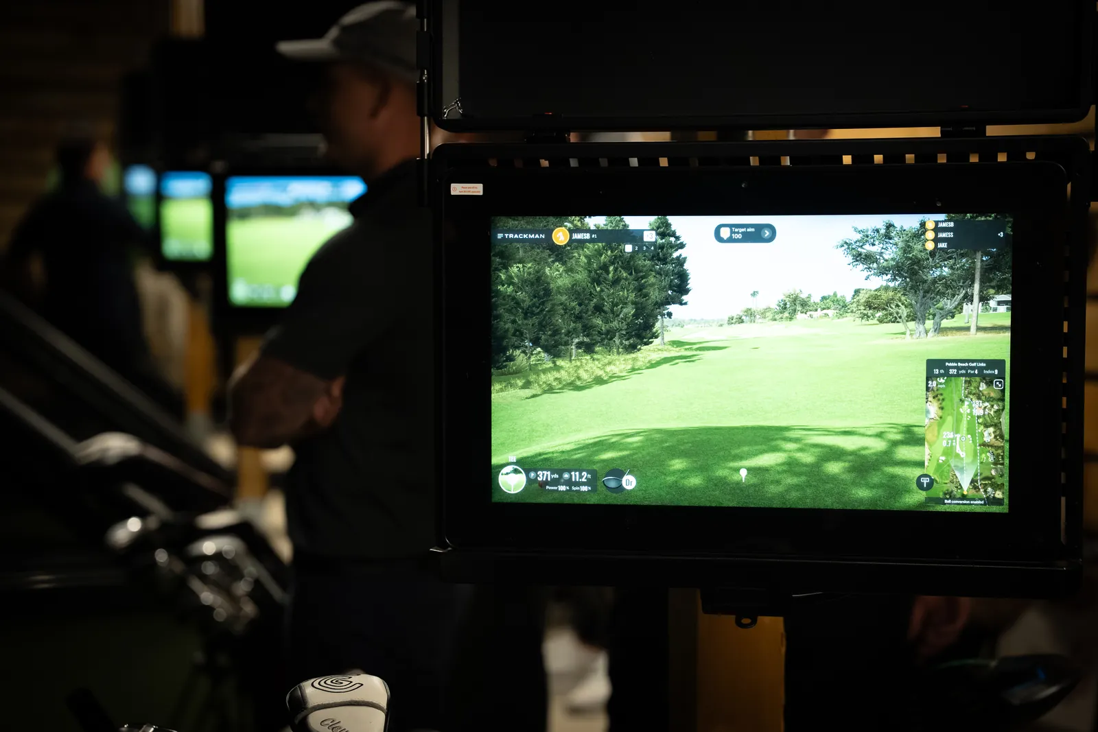 Over-the-shoulder view of a coach reviewing the TrackMan screen during a golf lesson at Evolution Golf Academy.