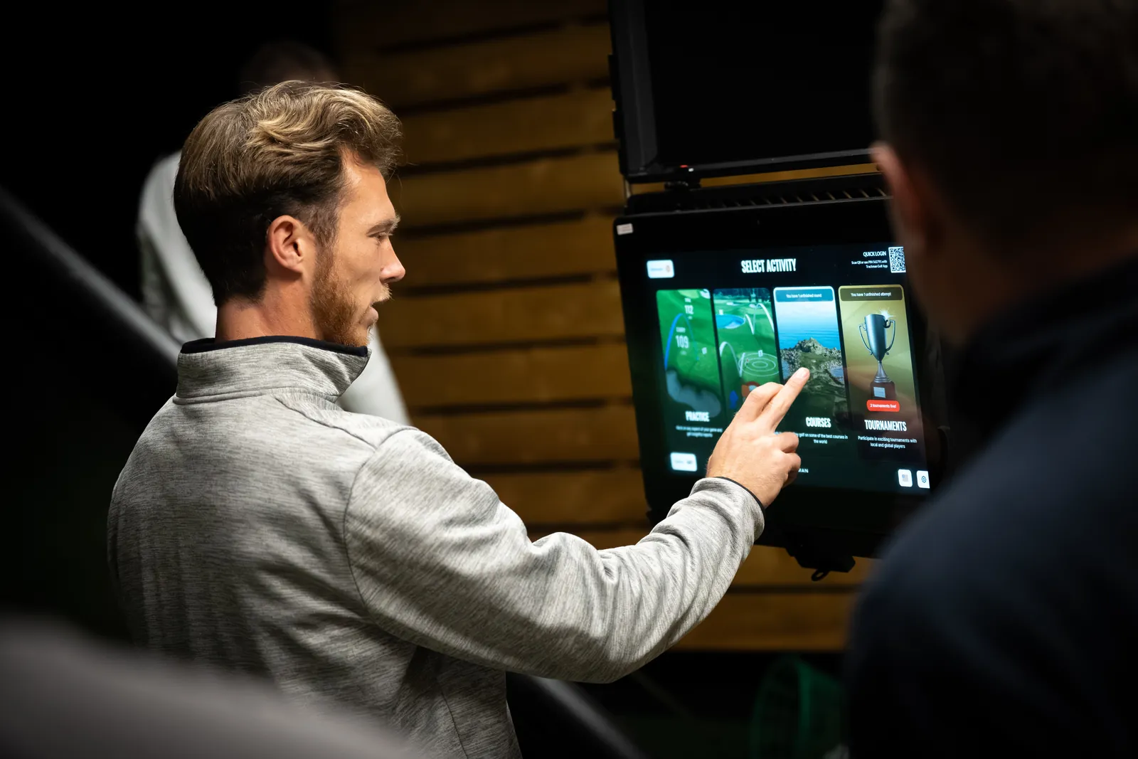 PGA coach giving TrackMan feedback to a student in an academy bay in Derbyshire.