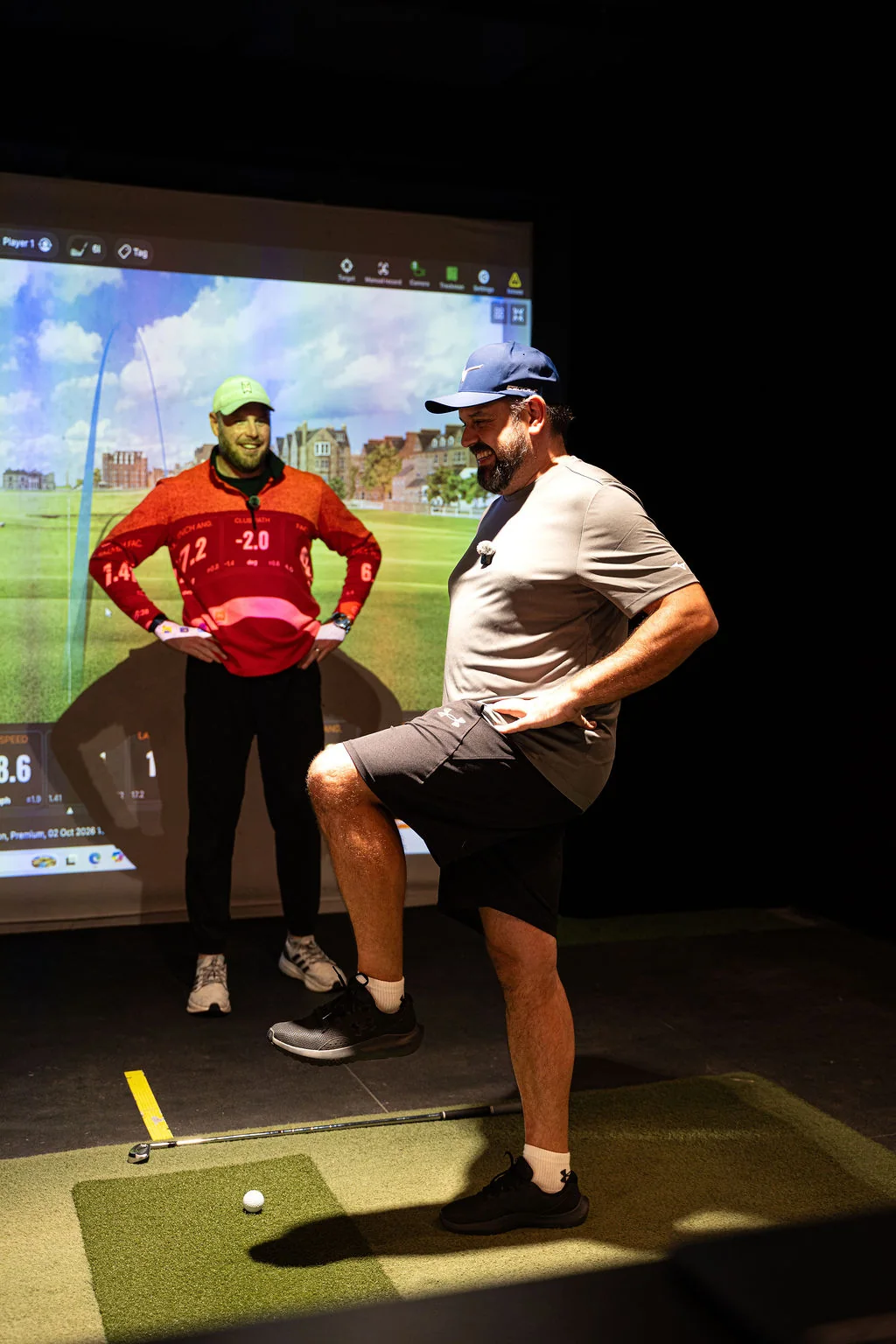 Golfer balancing on one leg in a TrackMan bay while a coach watches during a movement screening at Evolution Golf Academy near Derby
