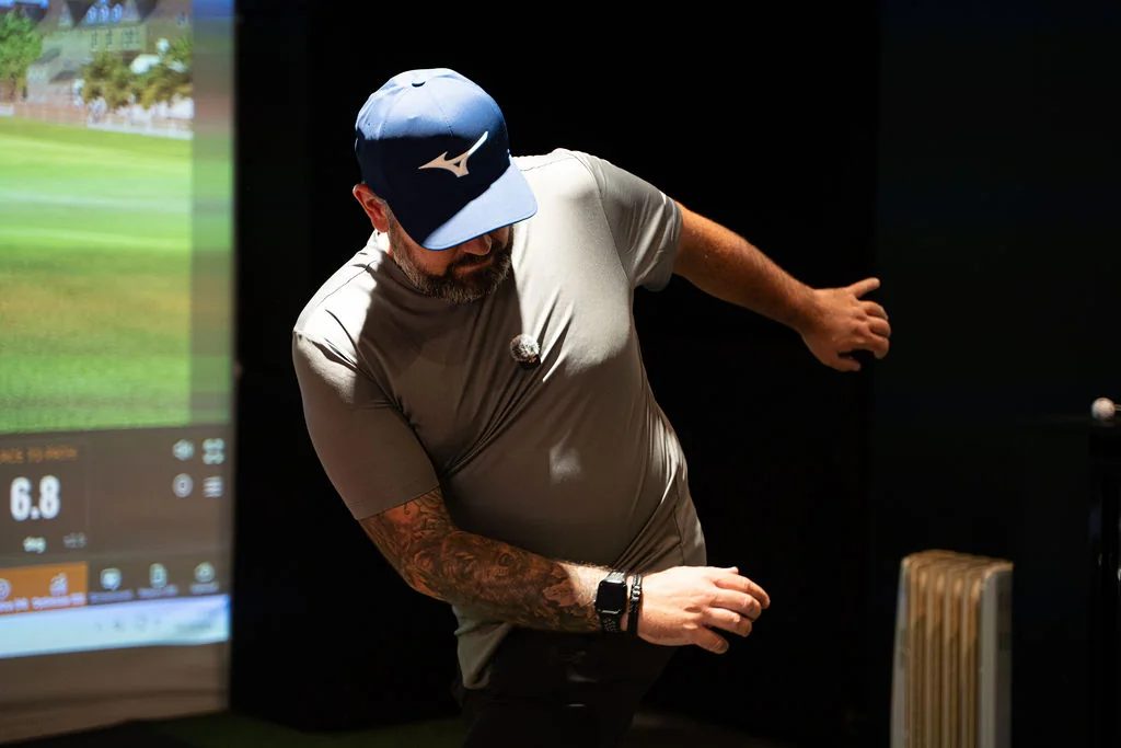 Golfer rotating the torso during a golf mobility screening in the TrackMan bay at Evolution Golf Academy near Derby