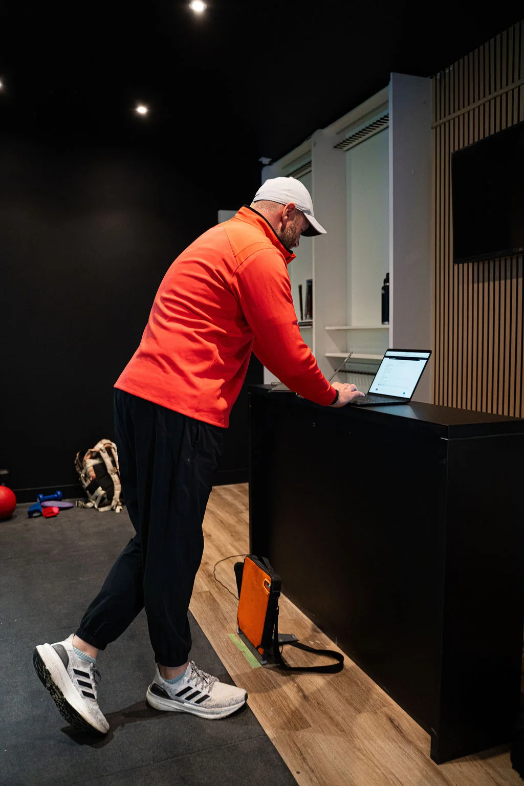 Strength and conditioning coach working at a laptop in the Evolution Golf Academy studio