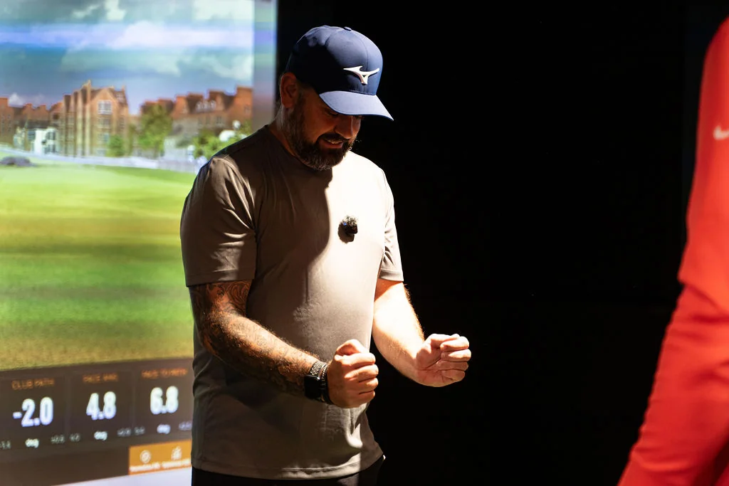 Golfer holding an arm position in front of the TrackMan screen during a golf fitness check at Evolution Golf Academy near Derby