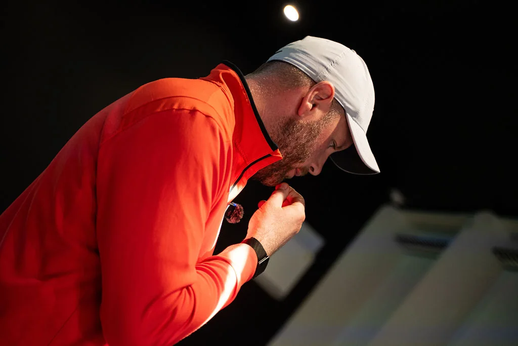 Coach looking down to review golf data during a coaching session at Evolution Golf Academy near Derby