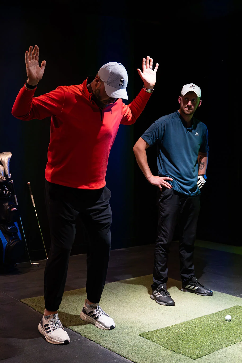 Coach and golfer both reaching overhead during a golf mobility screening on the hitting mat at Evolution Golf Academy near Derby