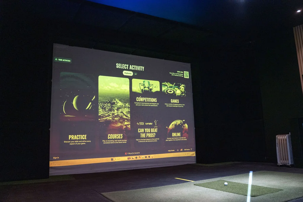 Projector screen showing the TrackMan select activity menu in the simulator bay at Evolution Golf Academy near Derby