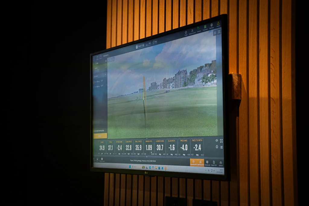 TrackMan simulator screen showing a fairway and shot data at Evolution Golf Academy near Derby