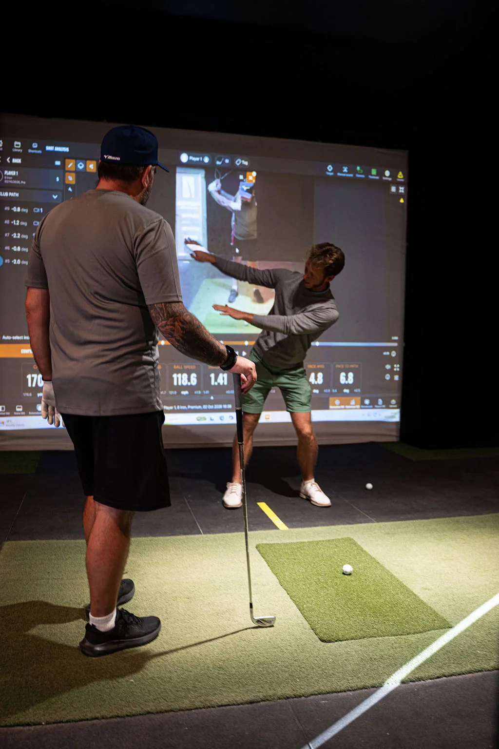 Golf lesson comparing a swing replay on the screen with the golfer in the foreground at Evolution Golf Academy near Derby