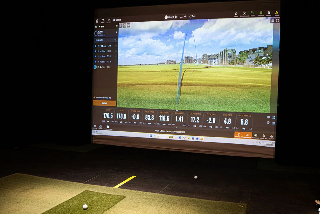 TrackMan simulator screen showing ball flight and shot data at Evolution Golf Academy near Derby