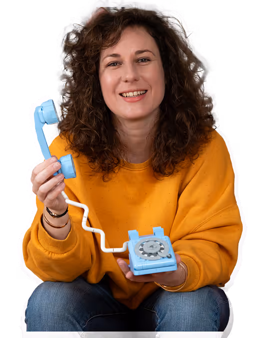 Photo de Pauline assise avec un téléphone Bleu en Lego dans la main