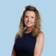 Beth Johnson headshot on sky blue background.