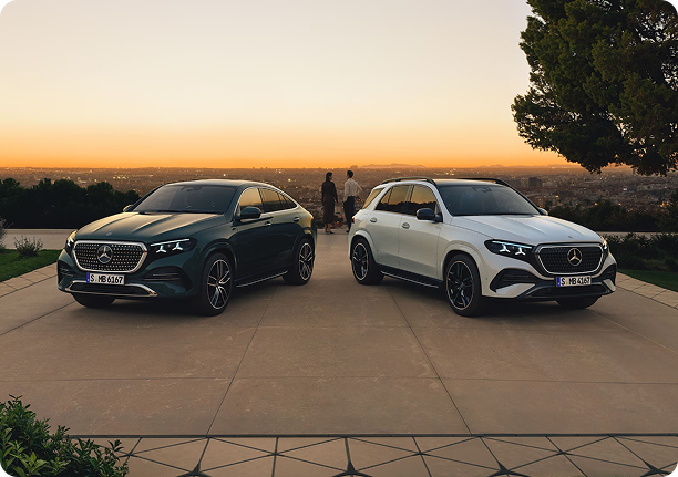 Two Mercedes-Benz SUVs parked on a terrace at sunset