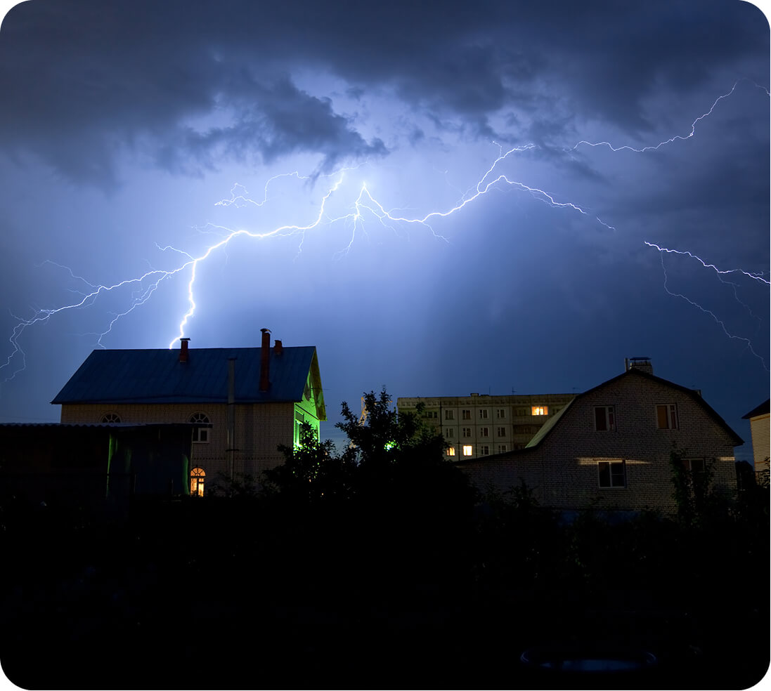 Thunderstorm over a neighborhood at night.
