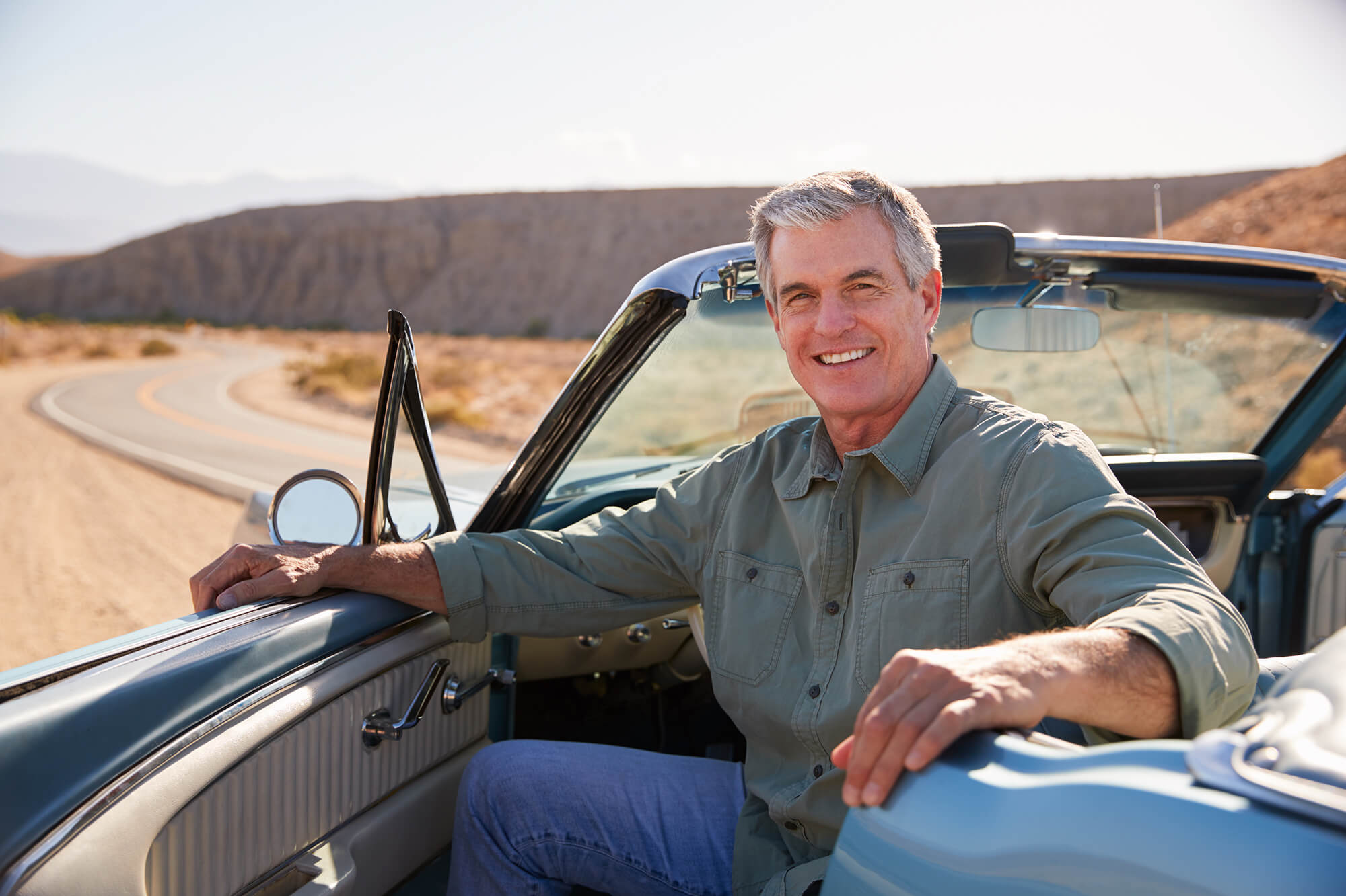 Smiling man enjoying a drive through the desert.