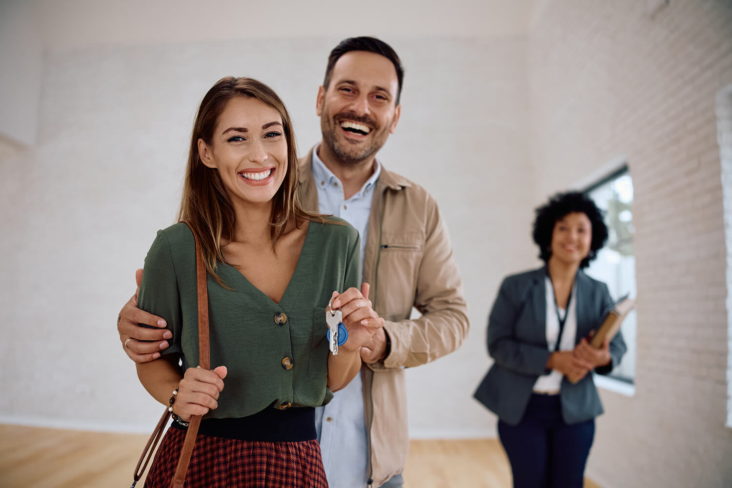 Couple excitedly receiving the keys to their new home.