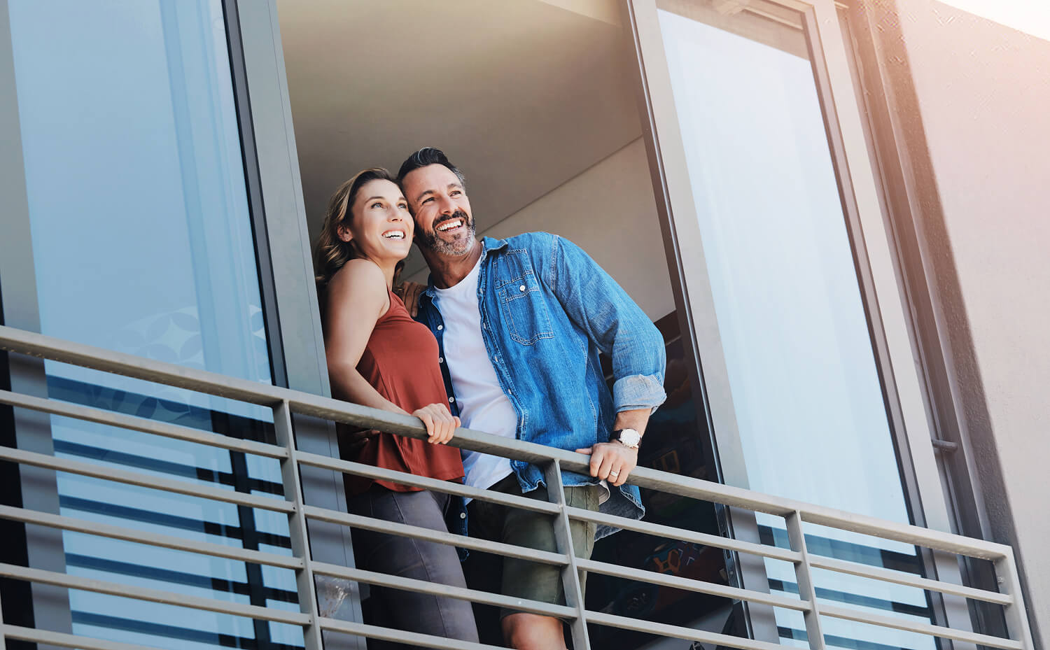 Happy couple enjoying the view from their balcony.