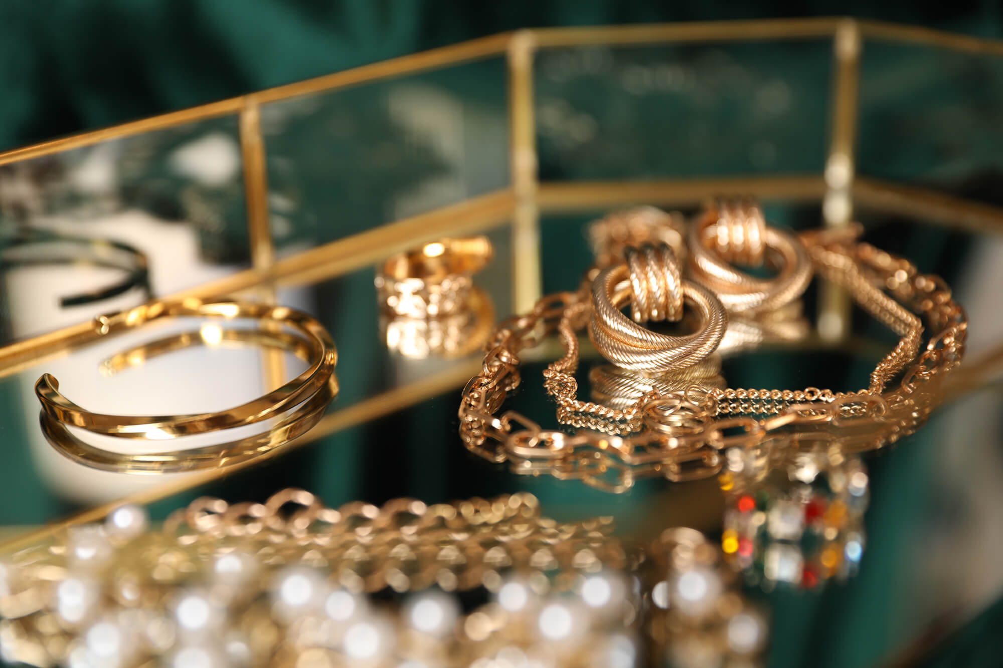 Gold jewelry displayed on a dark green cloth.